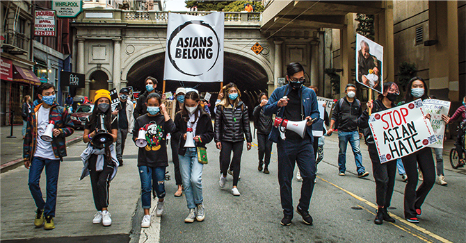 Enlargeable photo of Ashlyn marching with other teens with signs saying "Asians Belong"