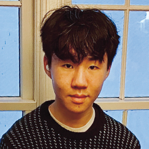 A young man with a slight smile wearing a black sweater