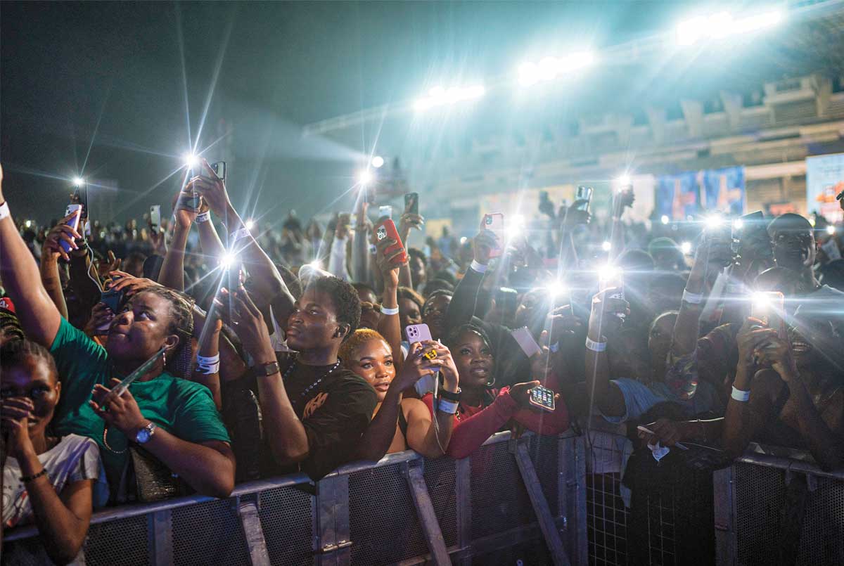 Photo of people at night in a crowd with their phones out