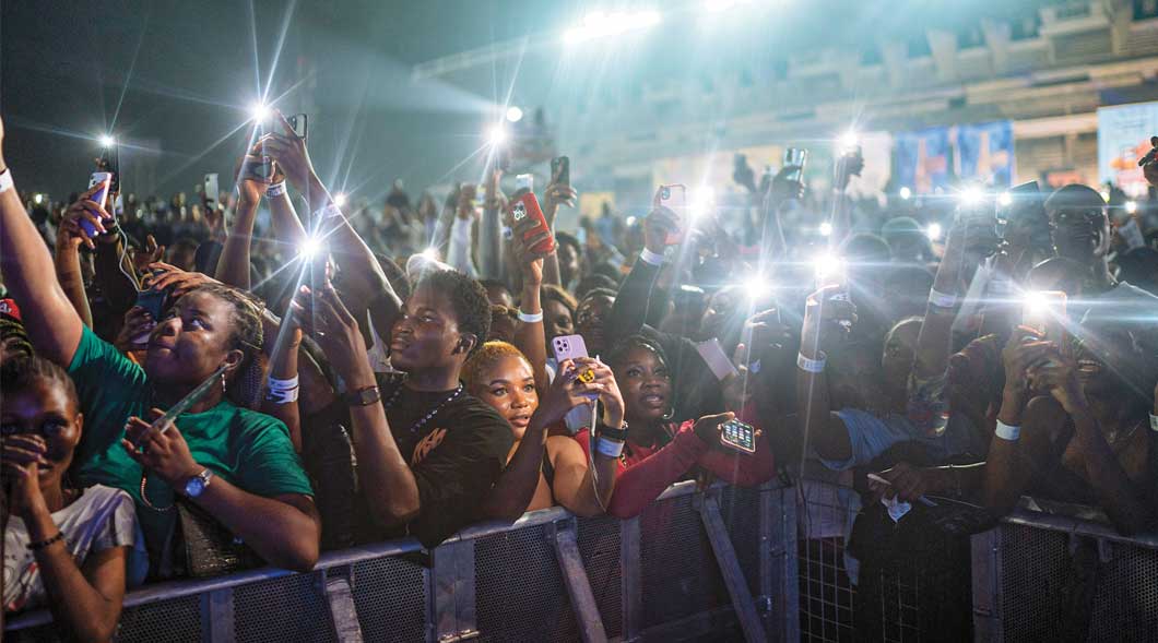 Photo of people at night in a crowd with their phones out