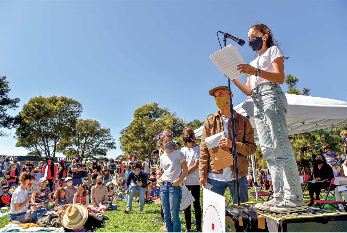 Photo of a teen giving a speech in front of crowd