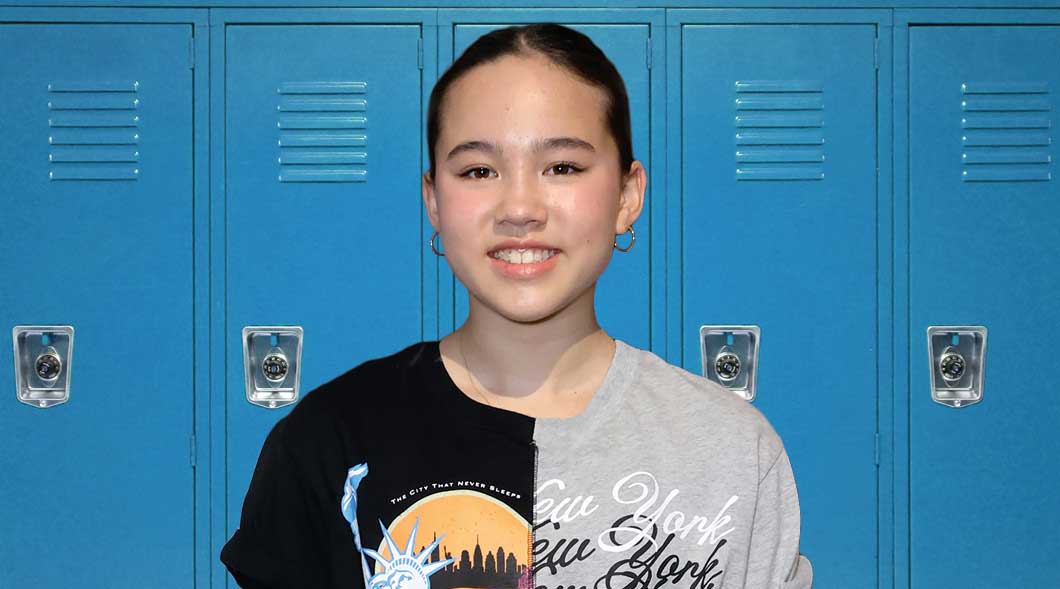 Photo of a teen standing in front of lockers