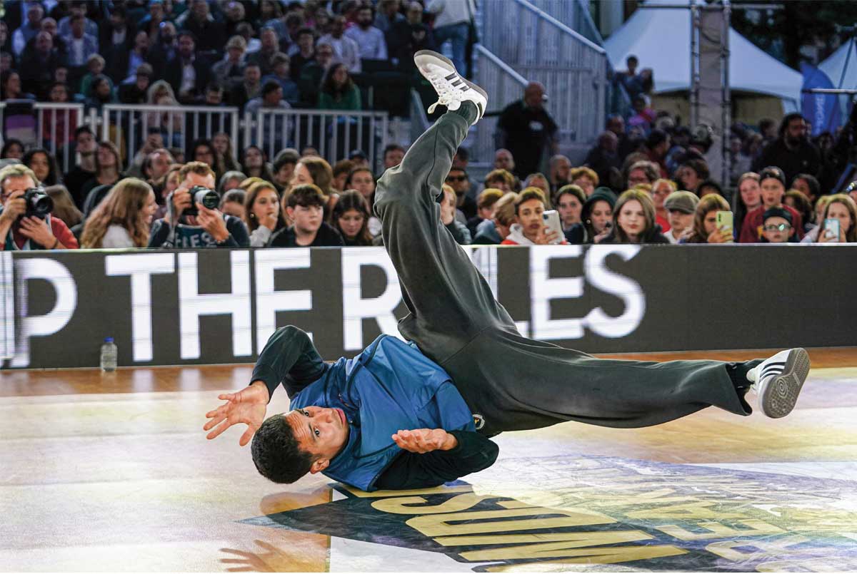 Photo of a break dancer performing in front of crowd