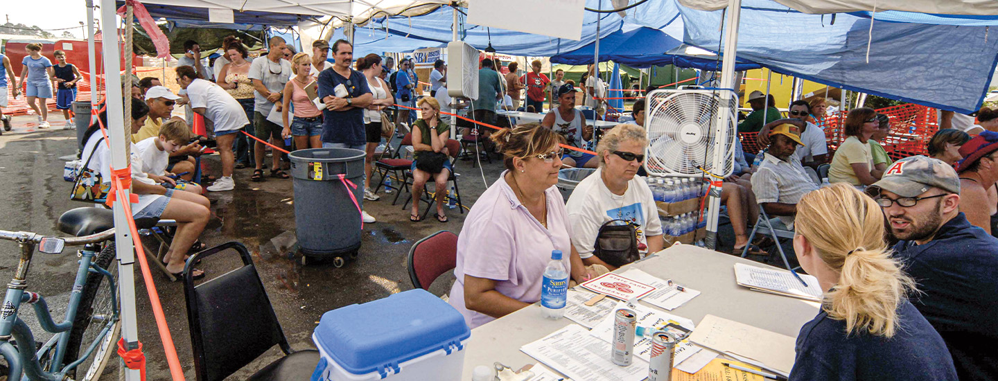 Image of people gathered under a hurricane relief tent